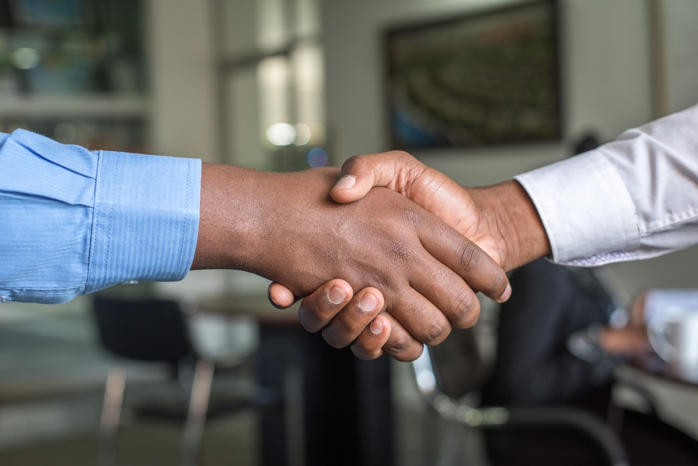 Two professionals shaking hands across a meeting table